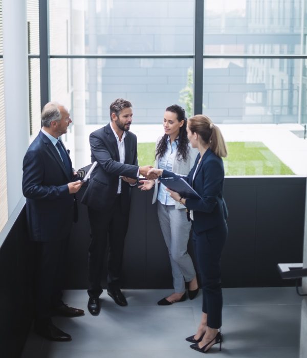 Group of businesspeople having a discussion near staircase in office