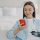 Smiling young disabled woman holding smartphone and glass of pure water. Female with bionic prosthetic arm using mobile phone apps, chatting in social networks, shopping online at home.